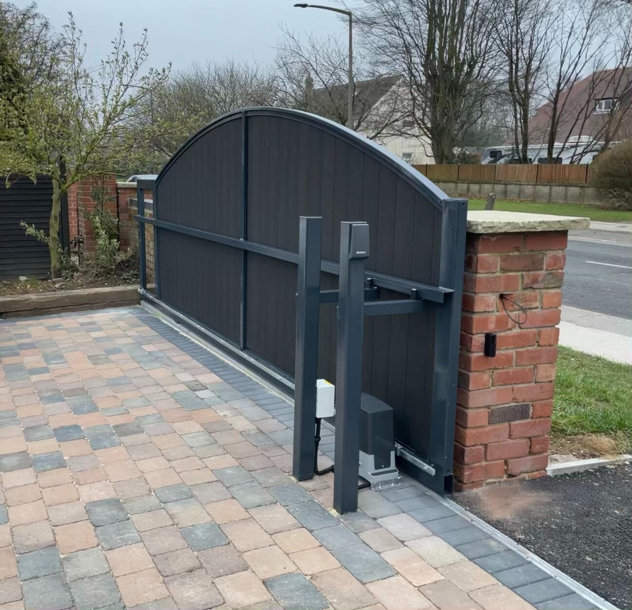 Sliding Gate Custom electric sliding driveway gate installation on a paved residential driveway.